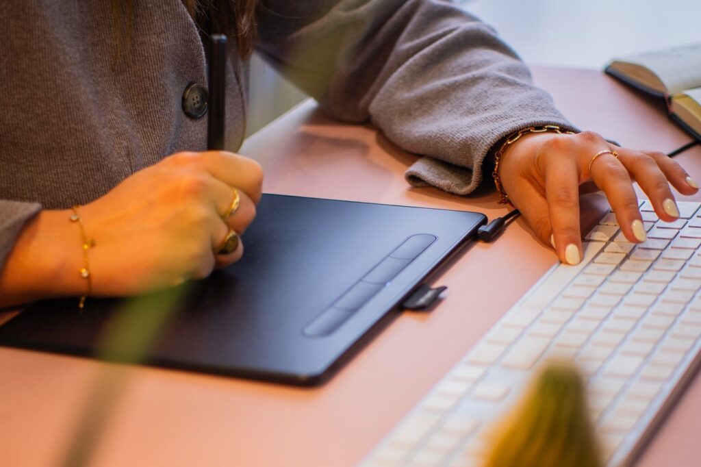 Hands on a graphics tablet and keyboard
