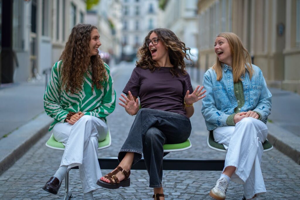 Three team members laughing together in the street