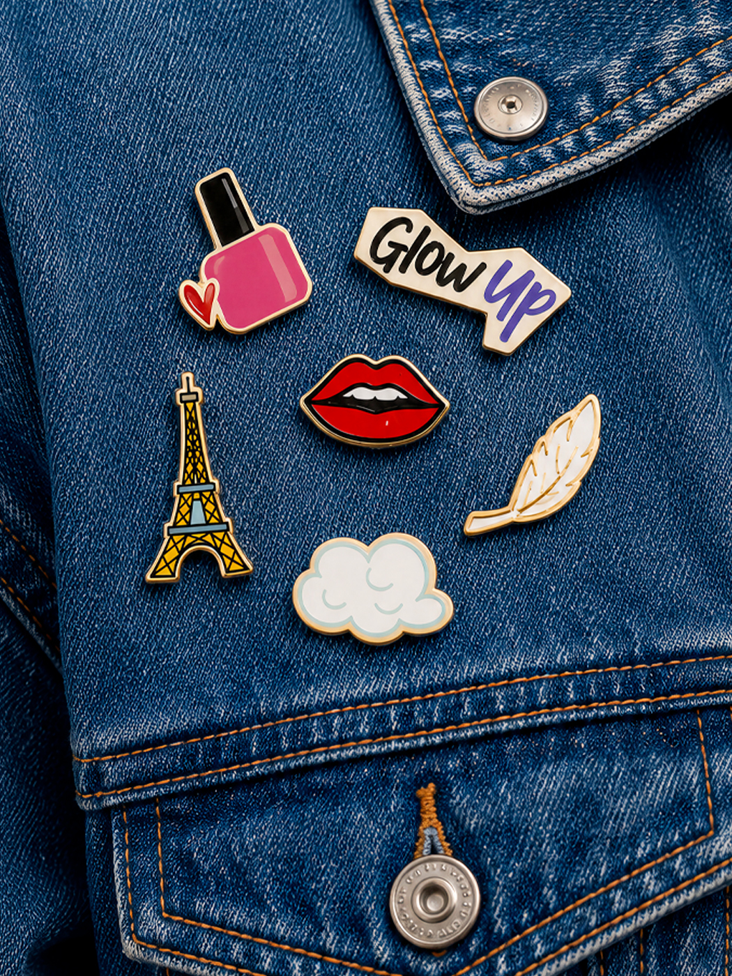 Pin's collector des éditions limitées sur une veste en jean : vernis, lèvres, tour Eiffel, nuage