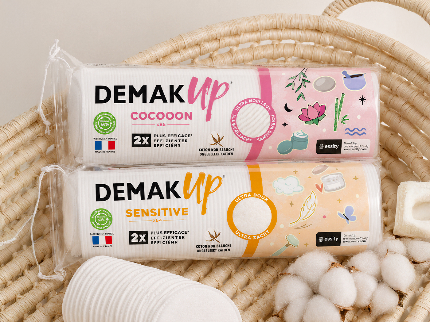 Étuis Demak'Up Cocooon et Sensitive dans un panier en osier, avec des fleurs de coton