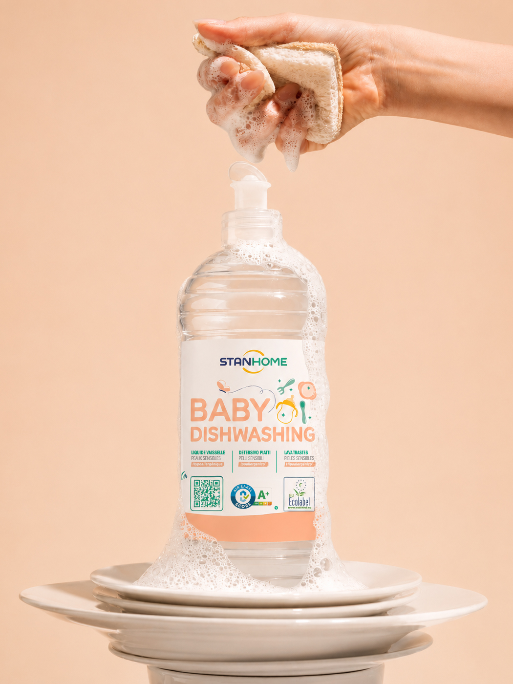 Flacon Stanhome Baby Dishwashing sous une éponge pressée, mousse sur une pile d'assiettes
